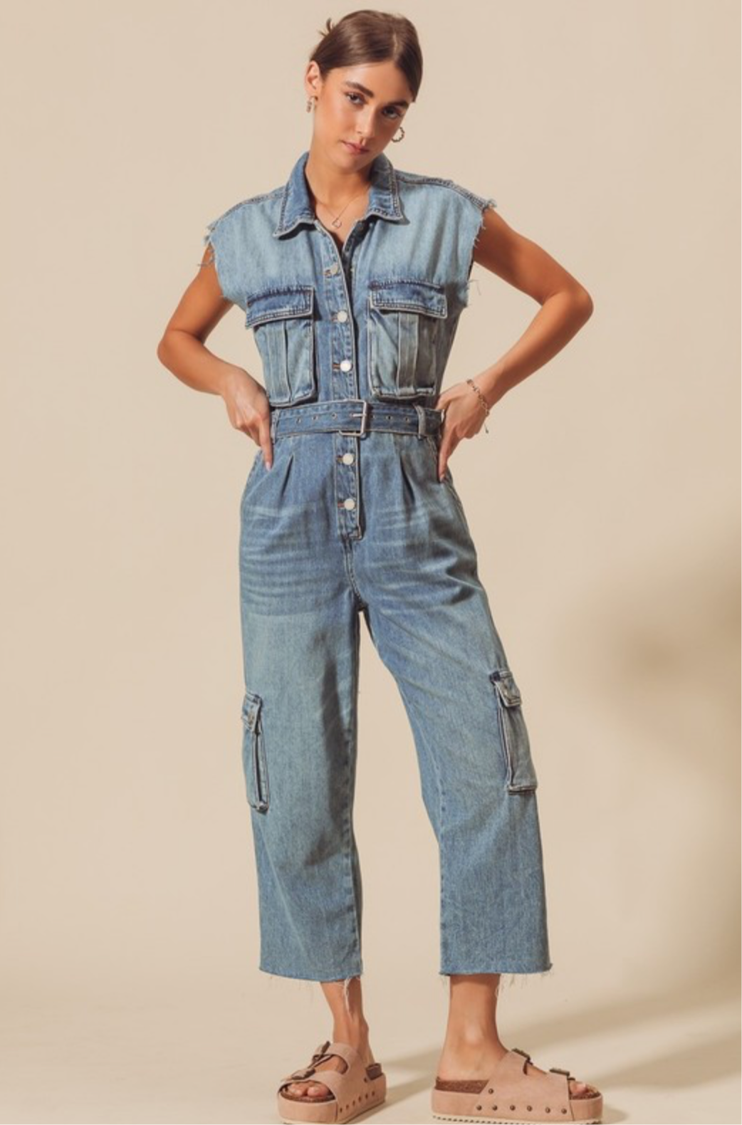 medium washed distressed sleeveless denim jumpsuit with cargo style details 